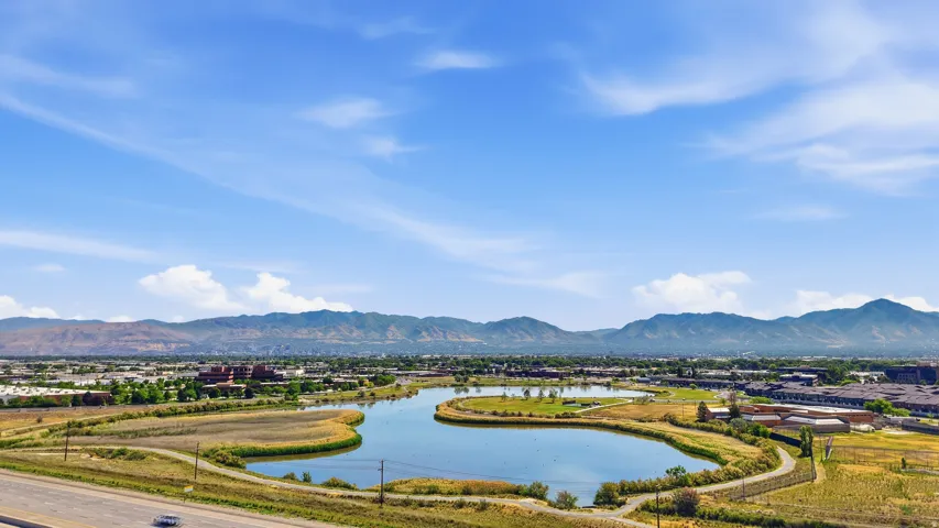 Expansive water feature with surrounding green spaces, set against a backdrop of distant mountains