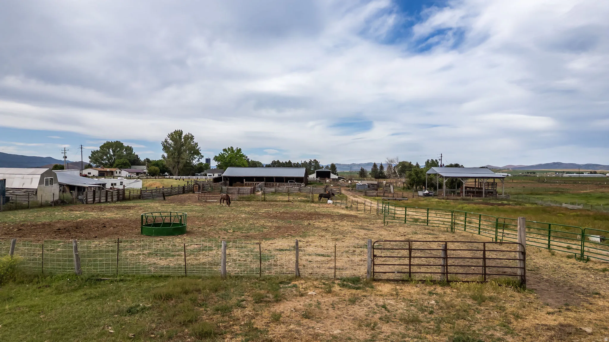 Expansive property featuring multiple outbuildings, fenced pastures, and open fields
