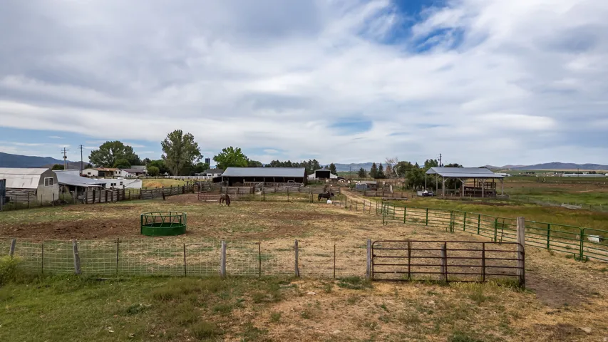 Expansive property featuring multiple outbuildings, fenced pastures, and open fields