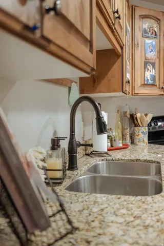 Kitchen sink area featuring a dual-basin stainless steel sink with an oil-rubbed bronze pull-down faucet