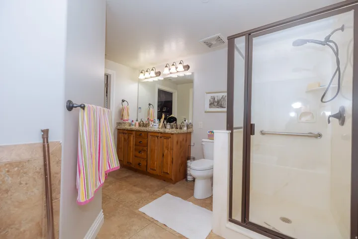 Bathroom featuring a glass-enclosed shower with bronze framing and a wall-mounted showerhead