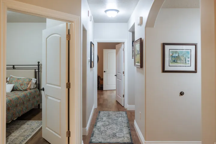 Hallway featuring wood-finish flooring, light neutral wall tones, white trim, and recessed lighting