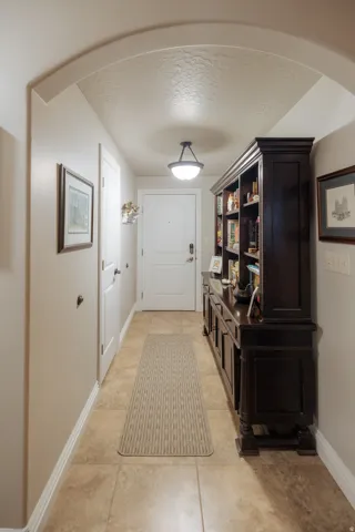 Archway entry featuring tile flooring, white baseboards, and a semi-flush mount ceiling light