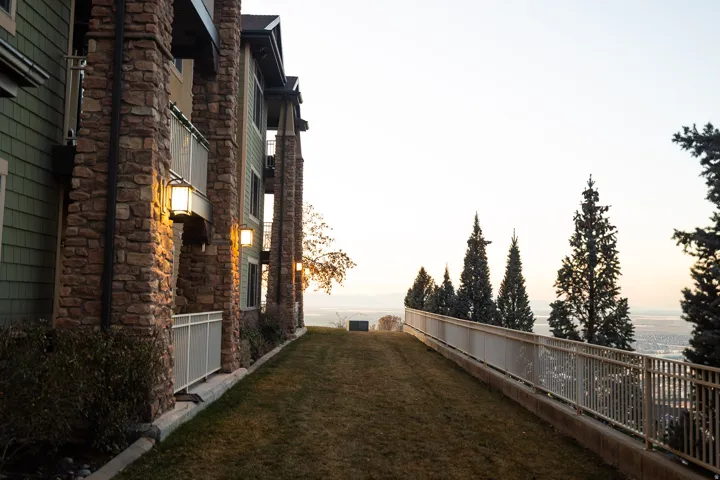 Multi-story building exterior featuring stone columns and green siding