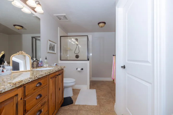Bathroom featuring a wood vanity with a granite countertop and integrated sink