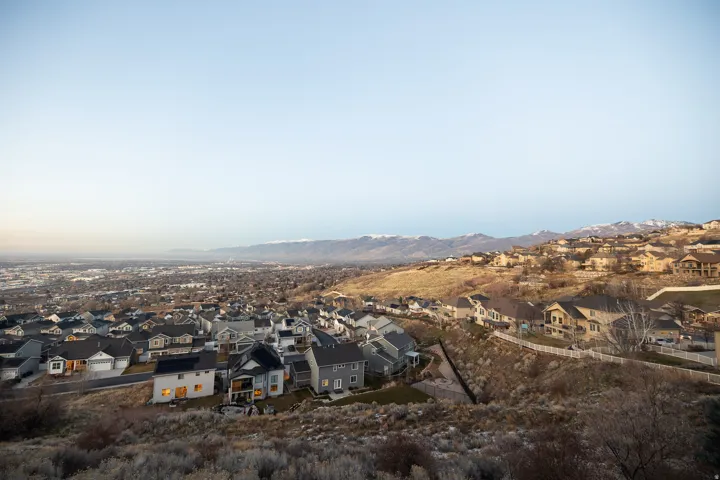 Expansive neighborhood with diverse architectural styles set against a distant mountain range
