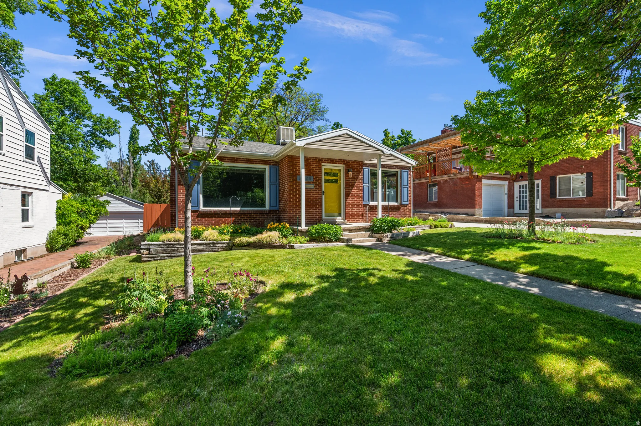 Brick exterior with a covered porch and vibrant yellow entry door