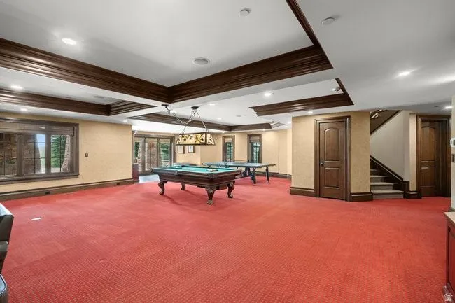 Spacious entertainment area featuring coffered ceilings, recessed lighting, and rich wood trim