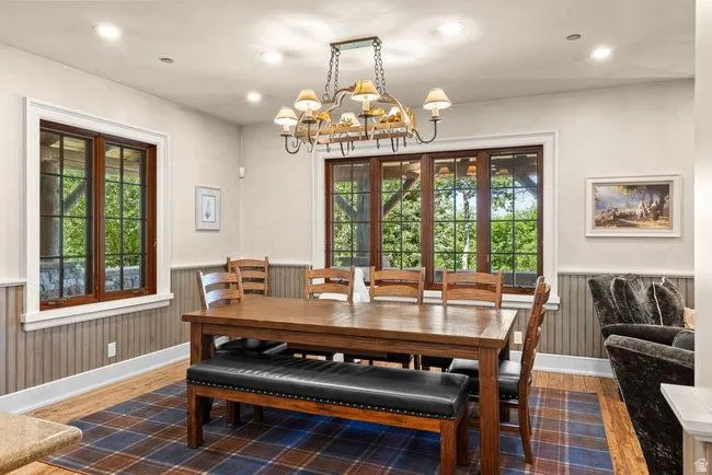 Spacious dining area featuring wood-finish flooring and a plaid area rug