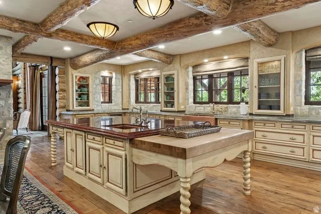 Chef's kitchen featuring exposed log beam ceiling, recessed lighting, and wood-finish flooring