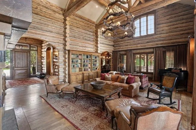 Grand living area featuring exposed log walls and ceiling beams