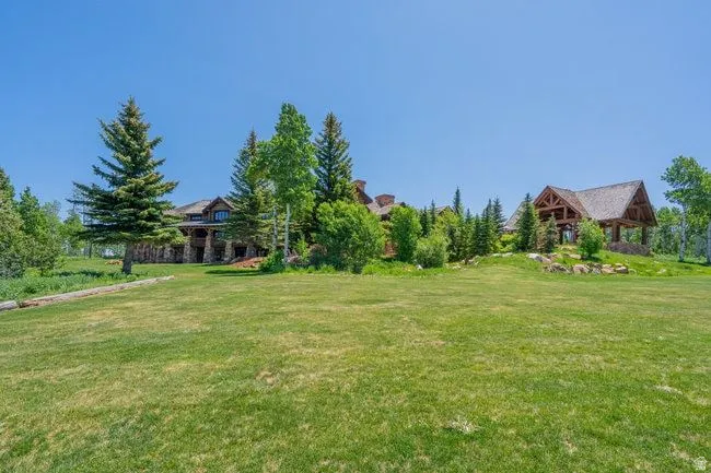 Expansive green lawn bordering a stone and timber-frame residence