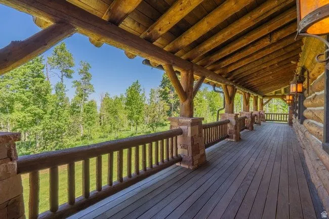 Expansive covered deck featuring natural log and stone architectural elements