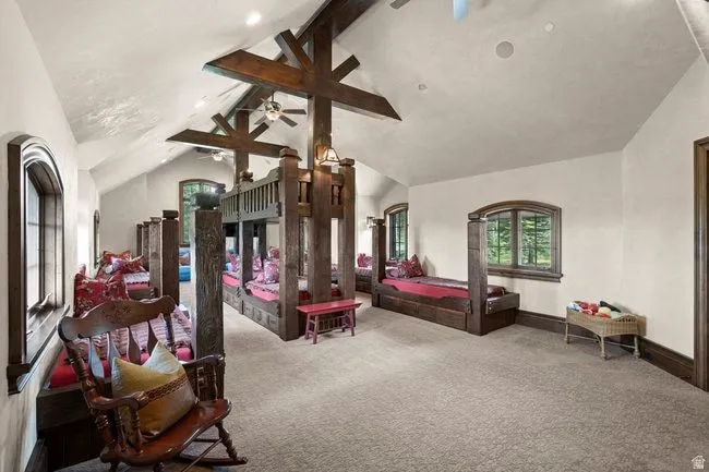 Vaulted ceiling with exposed wood beams, recessed lighting, and ceiling fans