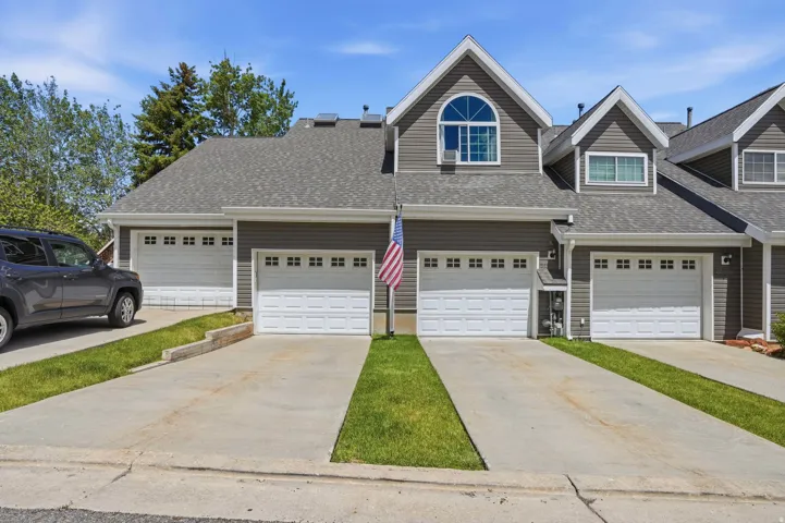 Gray multi-unit exterior featuring complementary white trim and multiple dormers