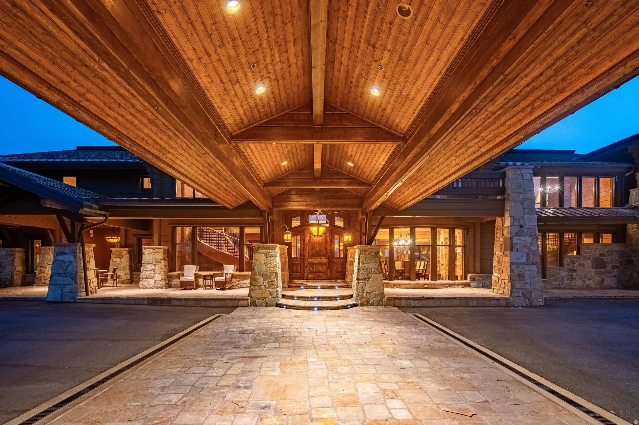 Grand porte-cochere entrance featuring a wood-panel ceiling with recessed lighting