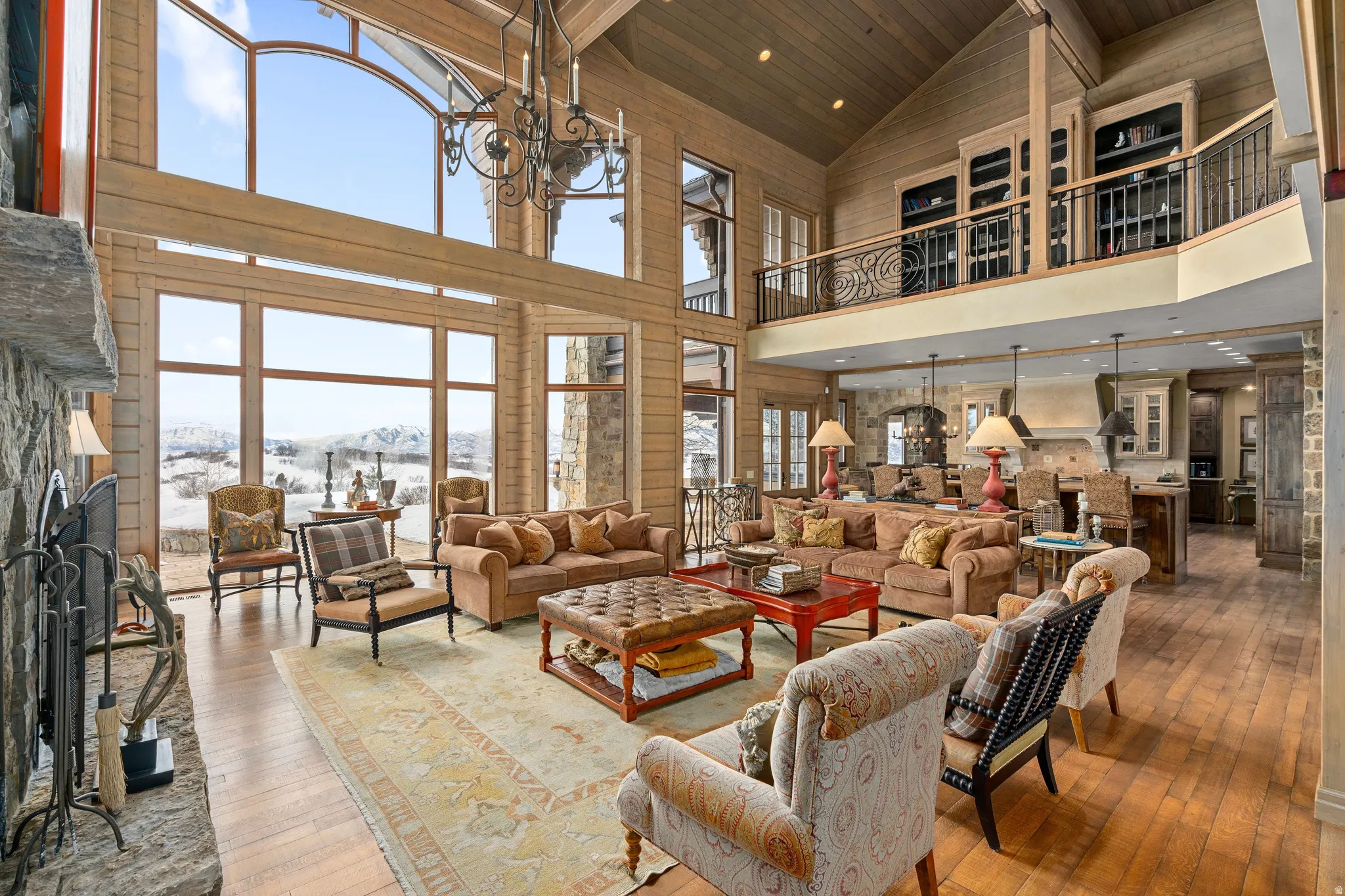 Great room with vaulted wood-plank ceilings, a stone fireplace, and a two-story window wall