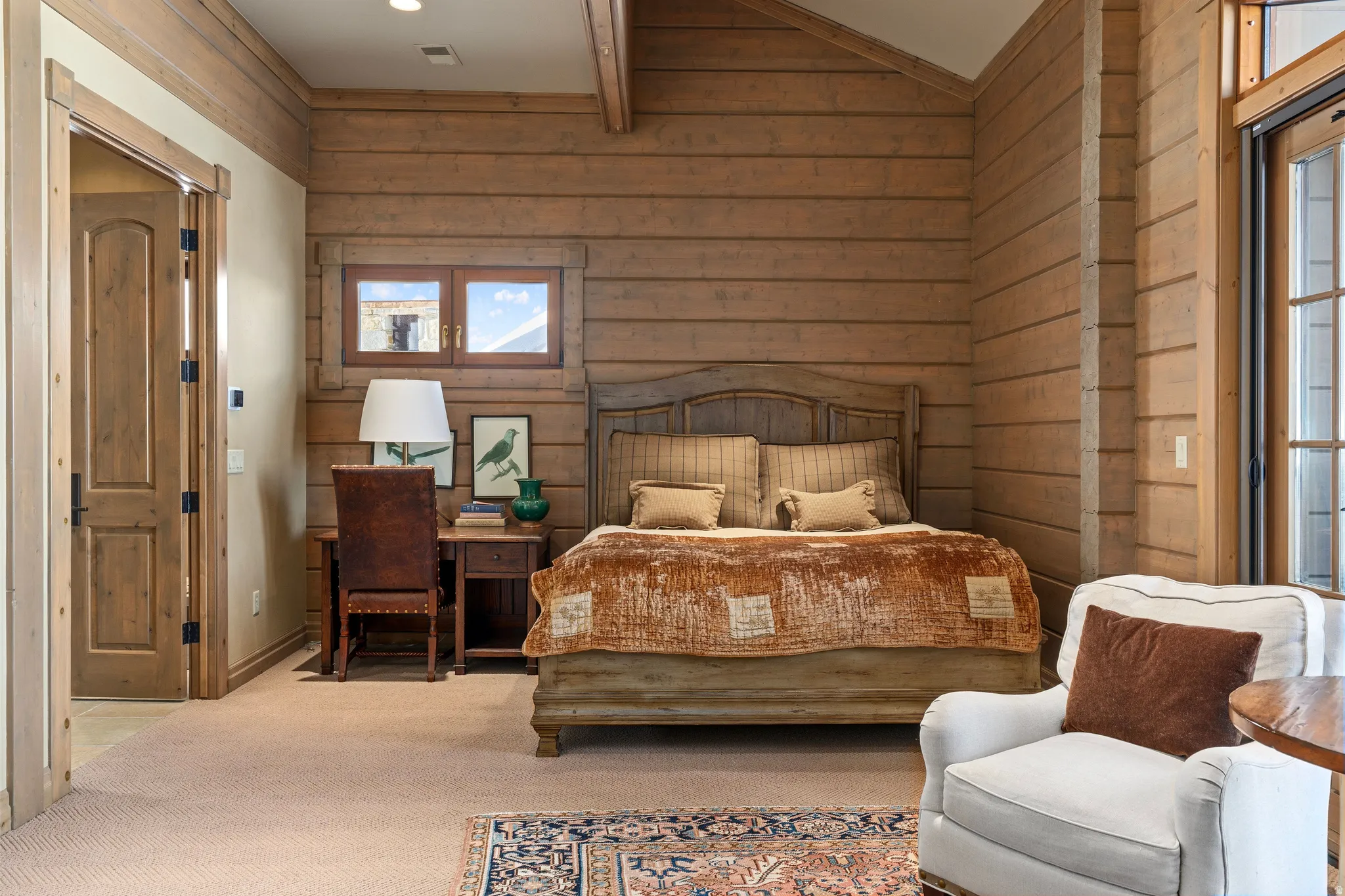 Rustic wood-paneled walls and ceiling beams define this interior space