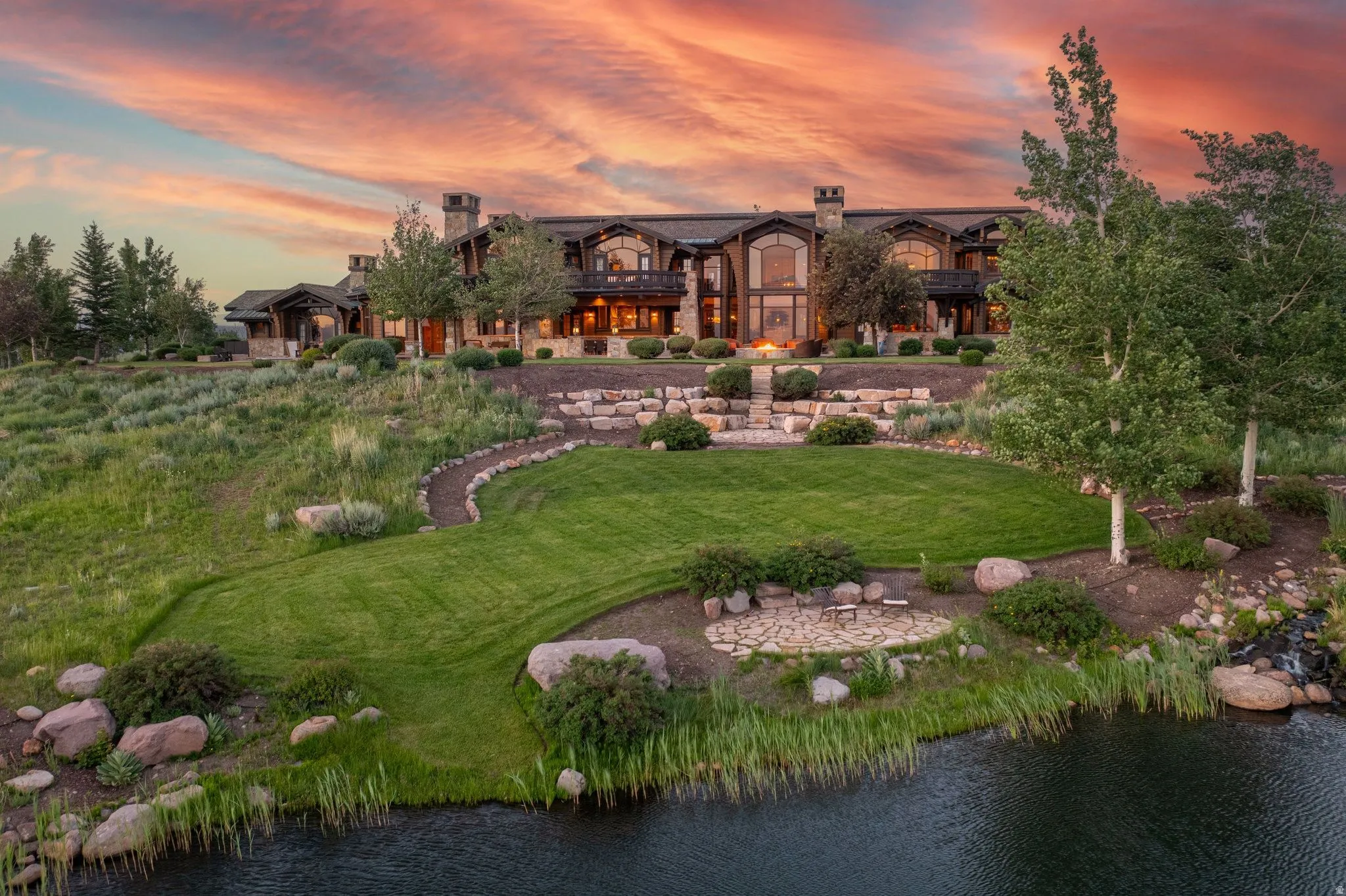 Sprawling estate featuring a stone and wood facade, multiple dormer windows, and a prominent chimney