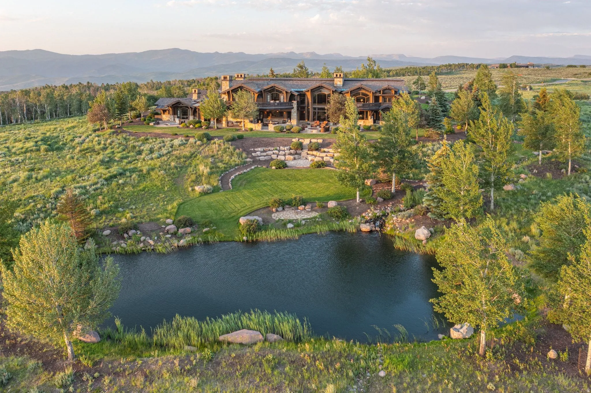 Expansive custom home featuring multiple levels, stone accents, and a prominent chimney