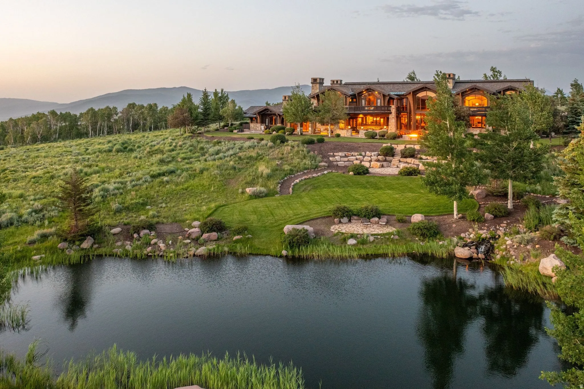 Expansive waterfront property featuring a large residence with multiple gables and dormers