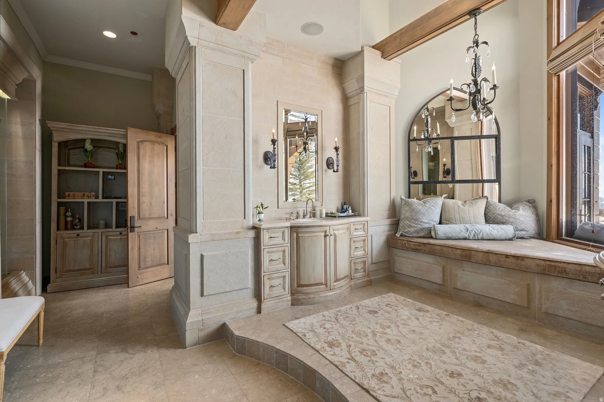Spacious room featuring light-toned stone flooring and a built-in window bench