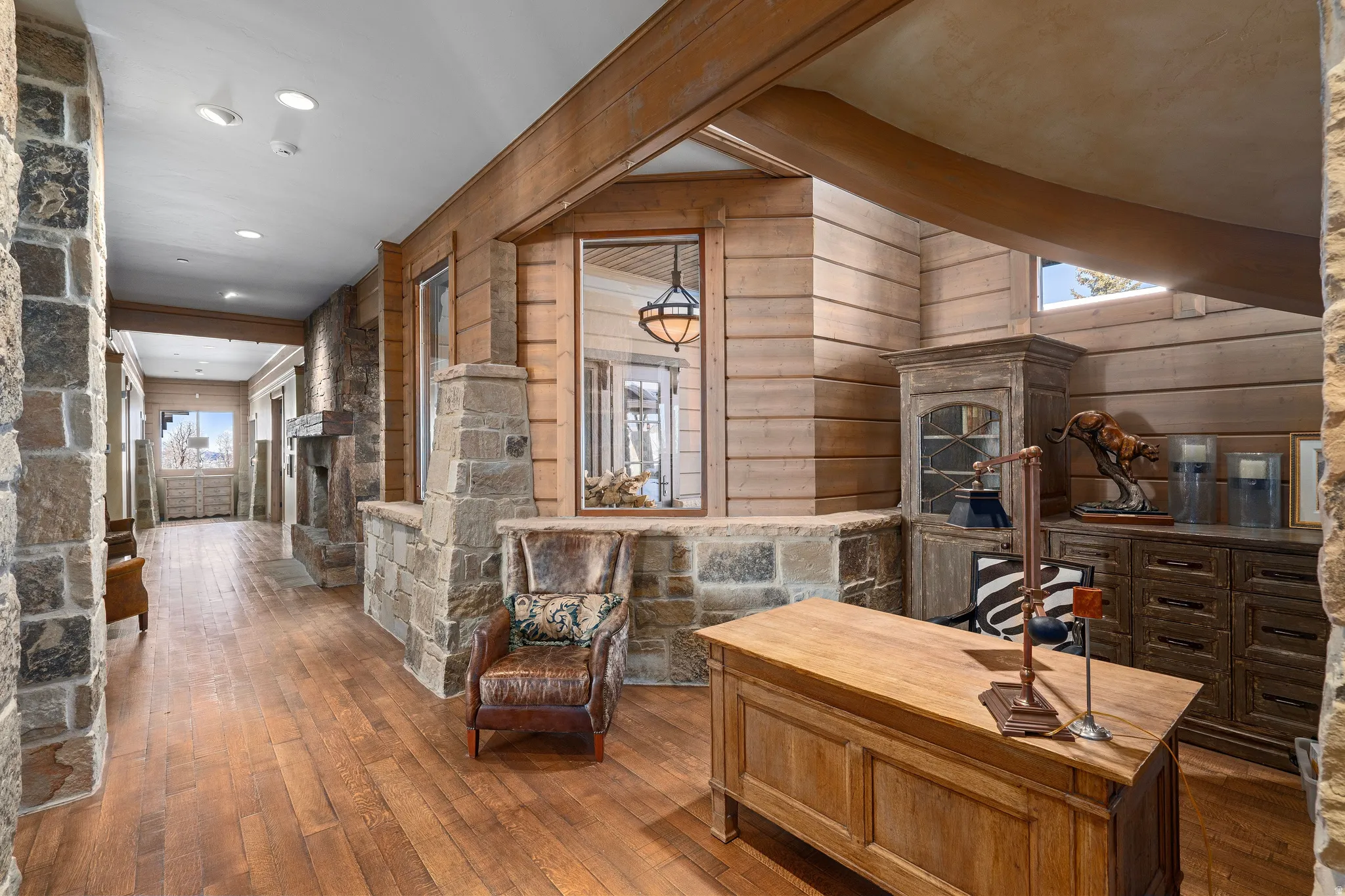 Entryway featuring stone columns, wood-finish flooring, plank wood walls, exposed wood beams, and recessed lighting