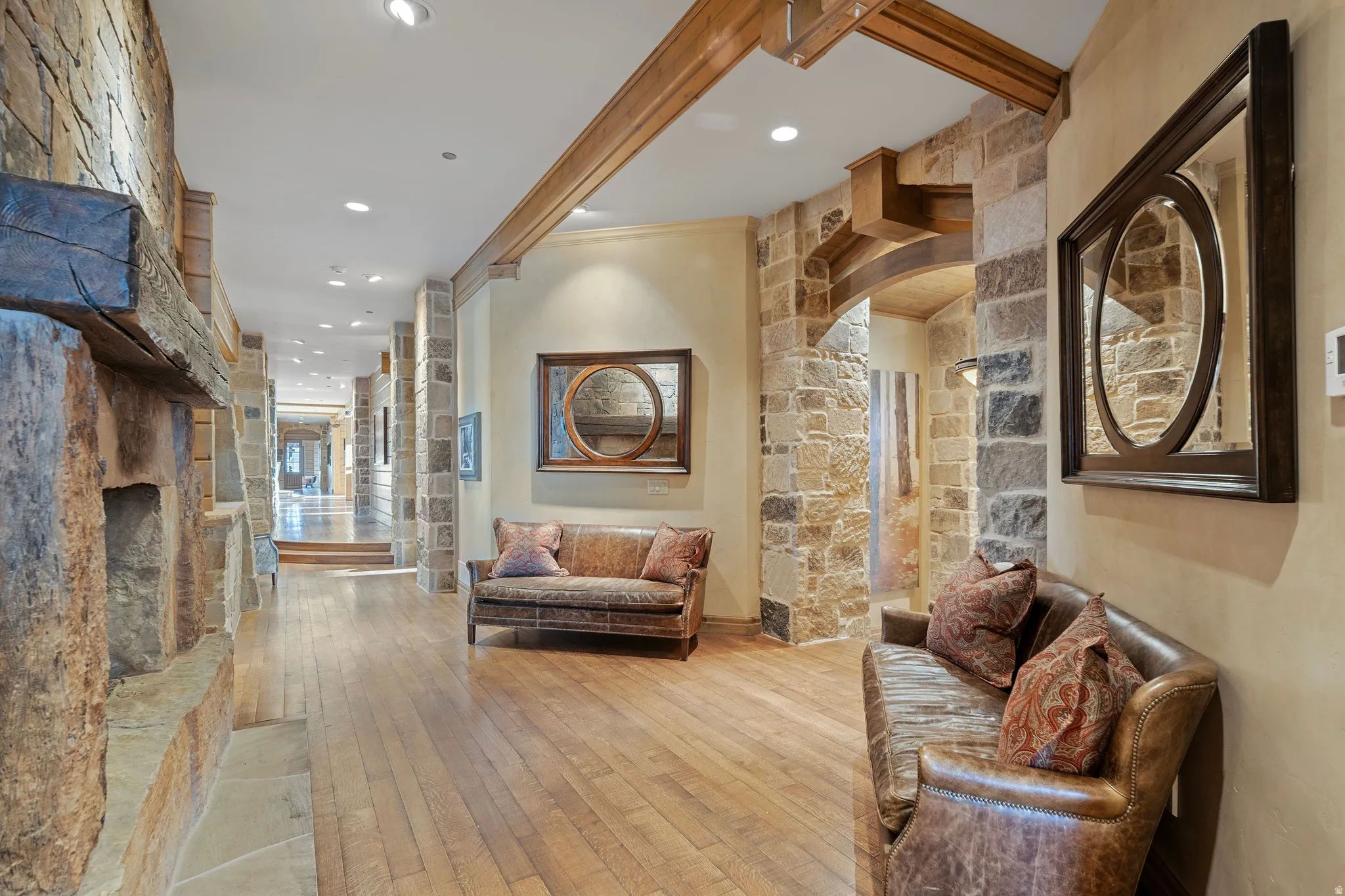 Hallway featuring wood-finish flooring, recessed lighting, and stone wall accents