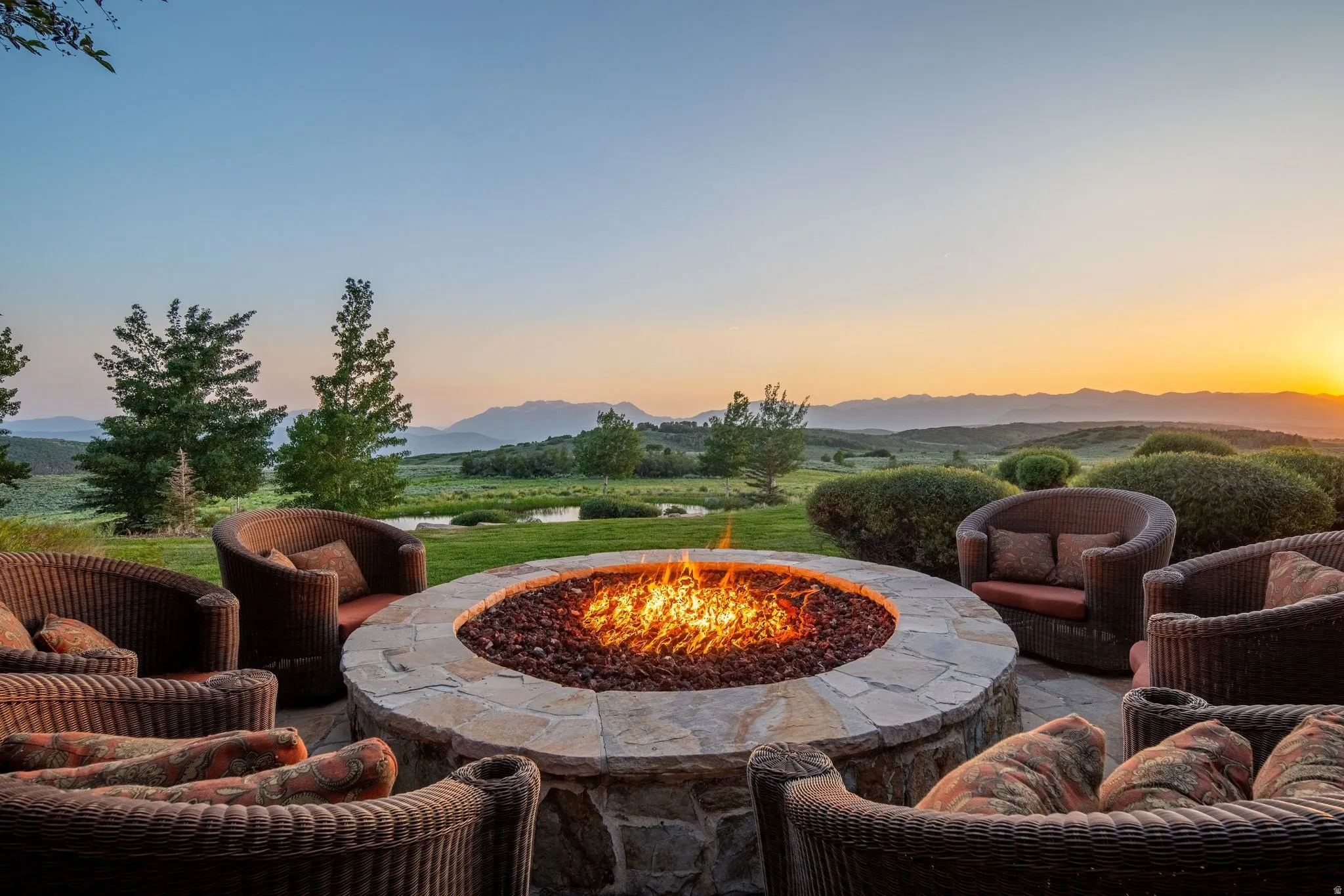 Stone fire pit with a natural stone surround and integrated seating area