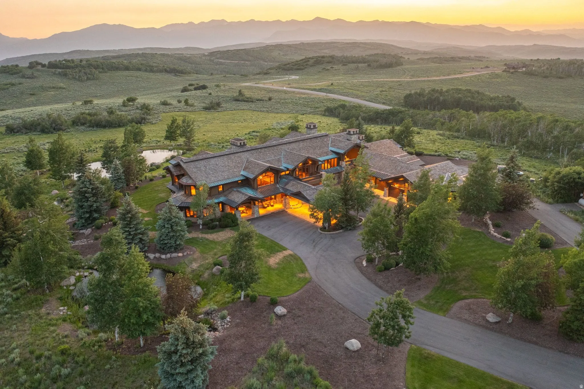 Expansive estate featuring a complex roofline, multiple gables, and a stone and wood exterior