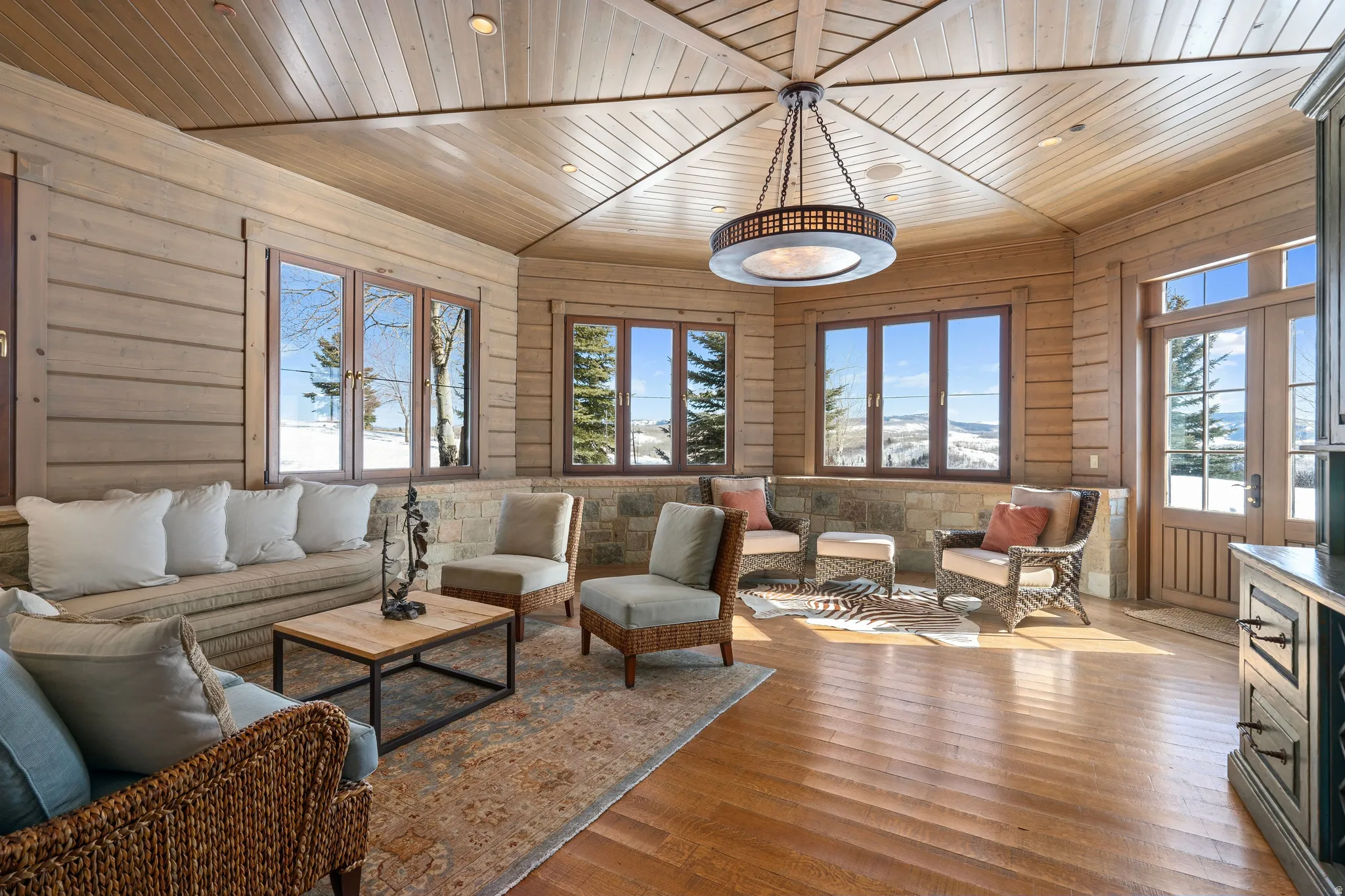 Sunroom featuring wood-finish flooring, a wood-paneled ceiling, and multiple windows