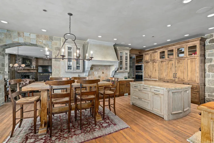 Spacious kitchen featuring stone accent walls and wood-finish flooring