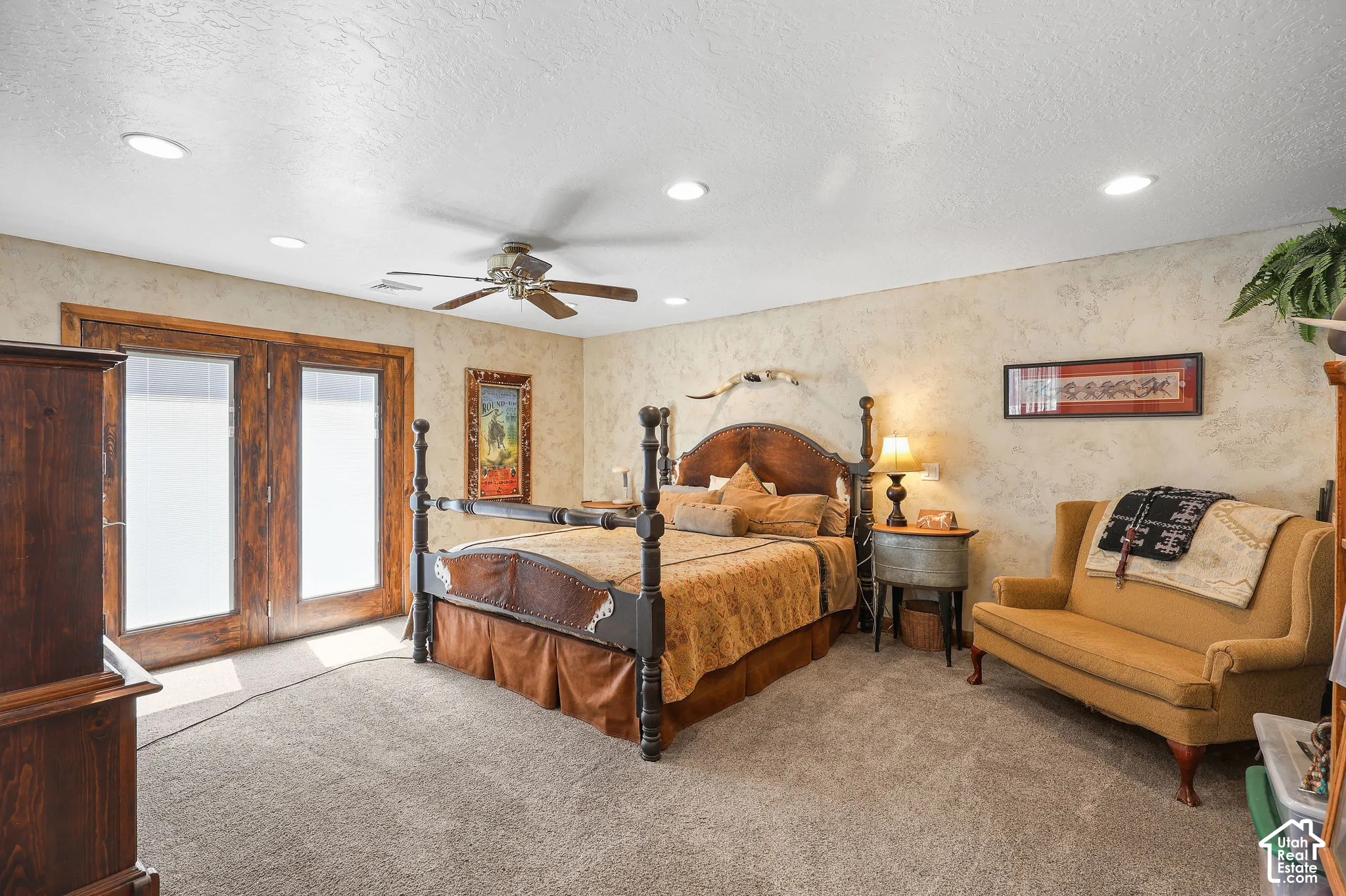 Primary room featuring a ceiling fan, recessed lighting, double French doors, textured wall finishes, and carpeting