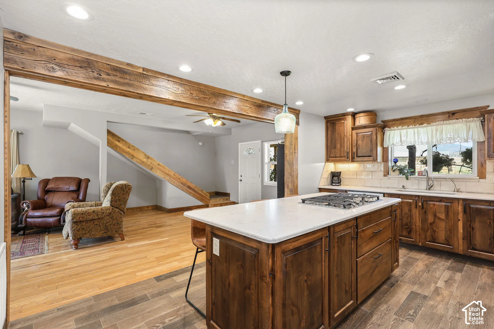 Kitchen featuring a central island with a built-in gas cooktop, white countertop, and wood cabinetry