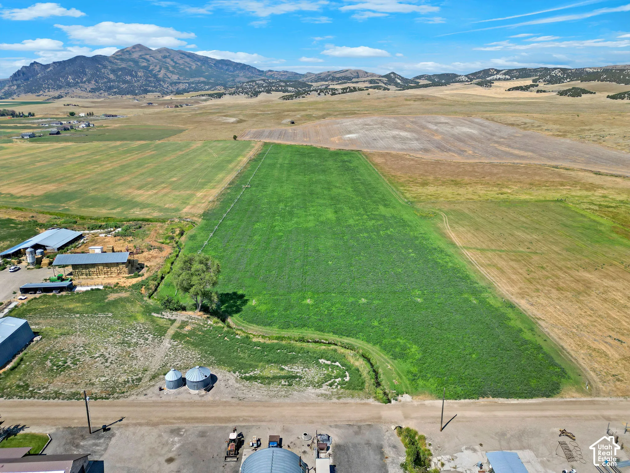 Expansive green field surrounded by varied agricultural terrain
