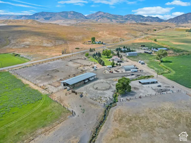 Expansive rural property featuring multiple outbuildings, fenced enclosures, and a large covered structure