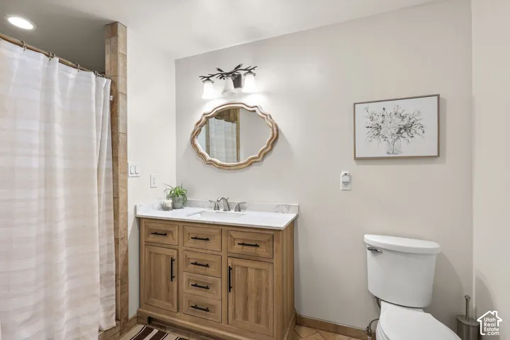 Primar bathroom featuring a light wood-finish vanity with ample storage, a white countertop, and a rectangular undermount sink
