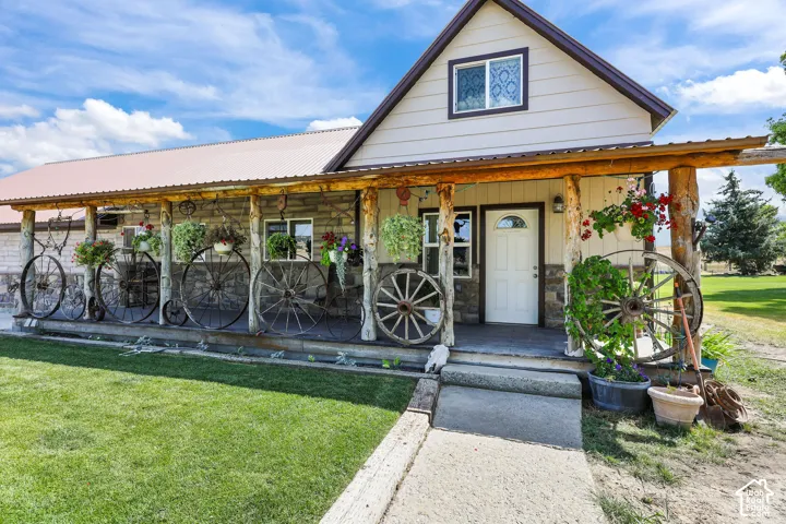 Stone-clad and paneled exterior featuring a covered porch with rustic log posts