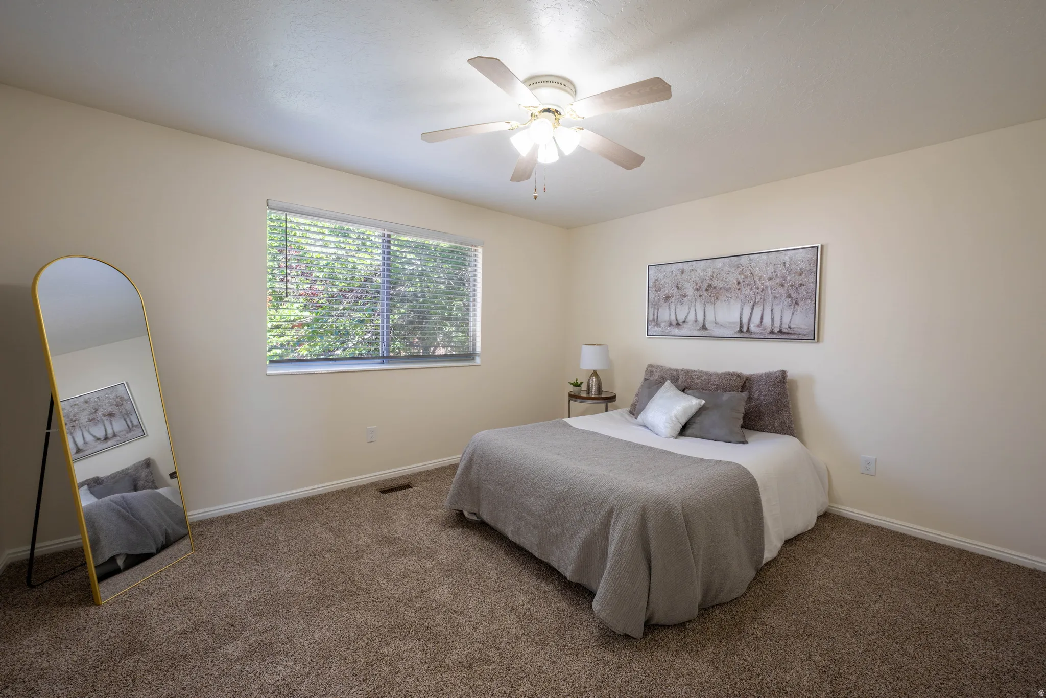 Carpeted room featuring a ceiling fan with integrated lighting, a window with blinds, and light-colored wall paint