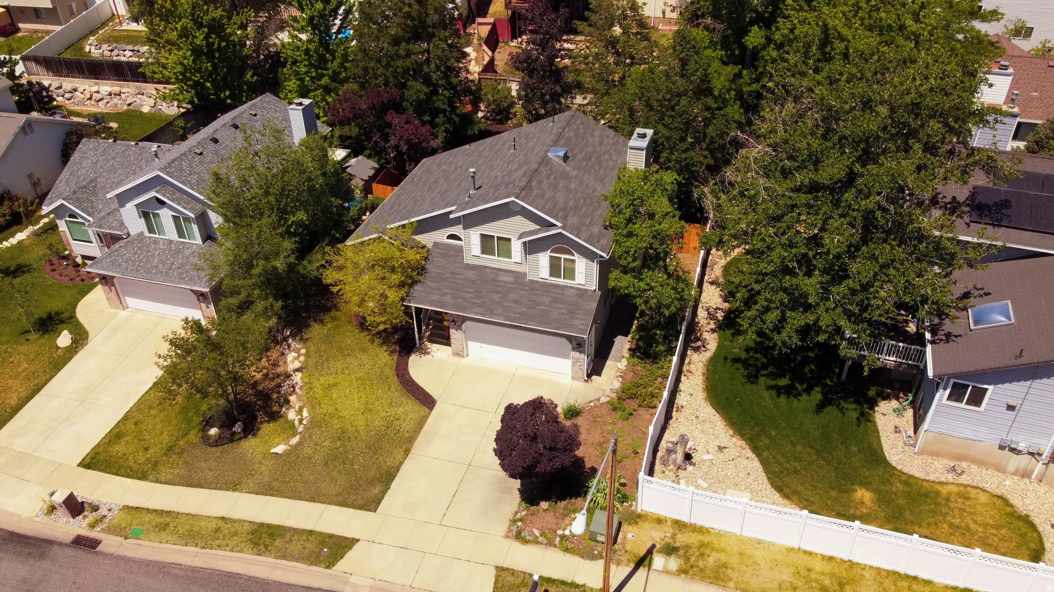 Two-story residence with a light gray exterior, featuring a dark gray shingle roof and white-framed windows