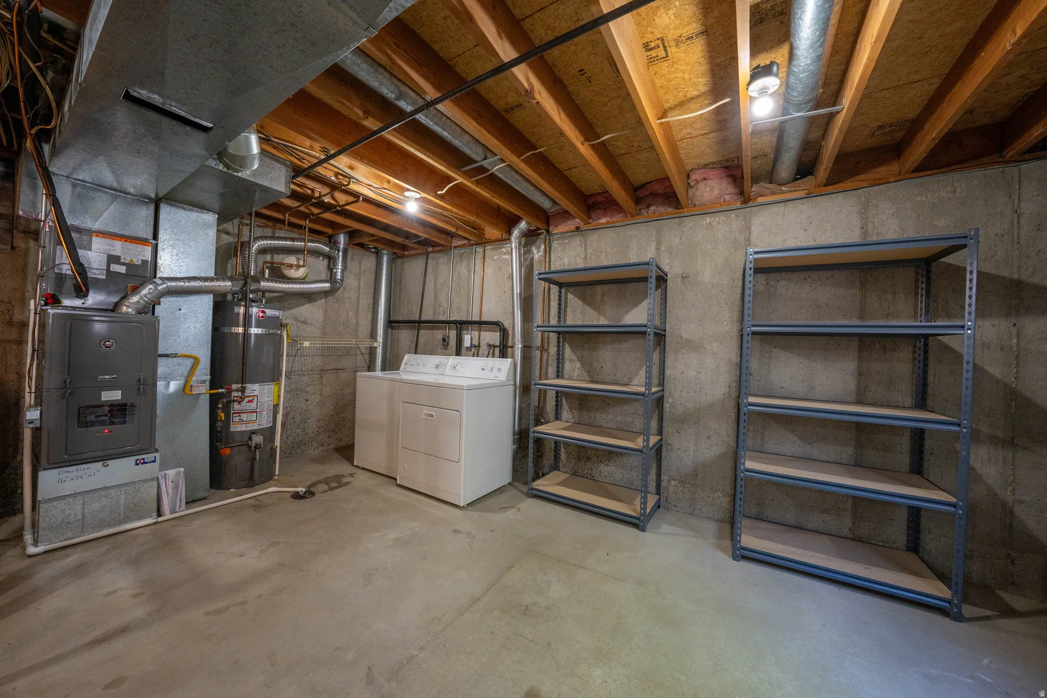 Unfinished basement featuring exposed wood joists, concrete flooring, and concrete block walls