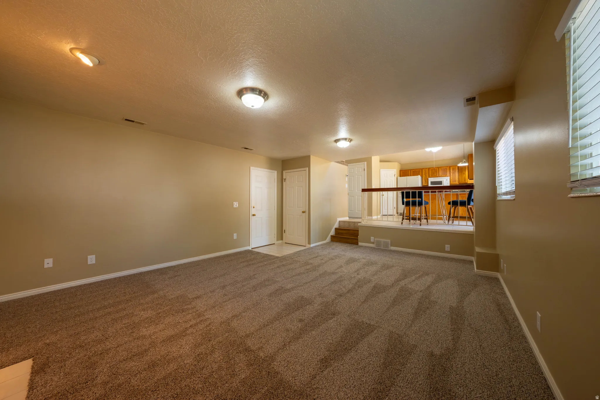 Expansive carpeted living space featuring recessed lighting and a stepped-down design