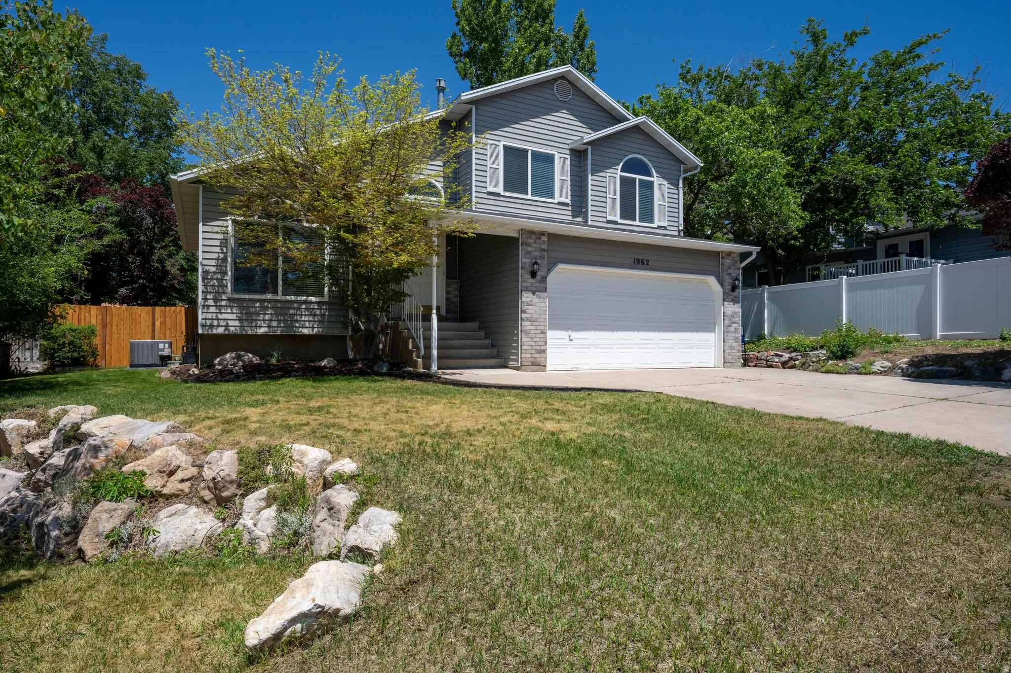 Two-story property featuring siding and stone facade, an attached two-car garage, and a concrete driveway