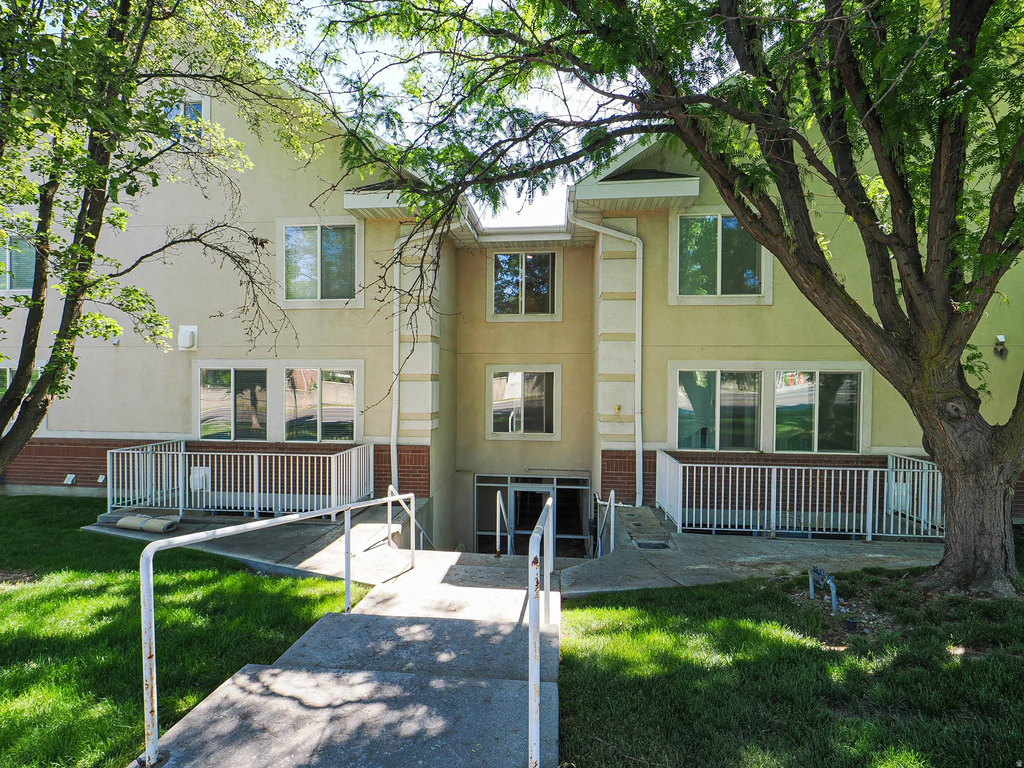 Multi-level building exterior featuring stucco siding and brick veneer