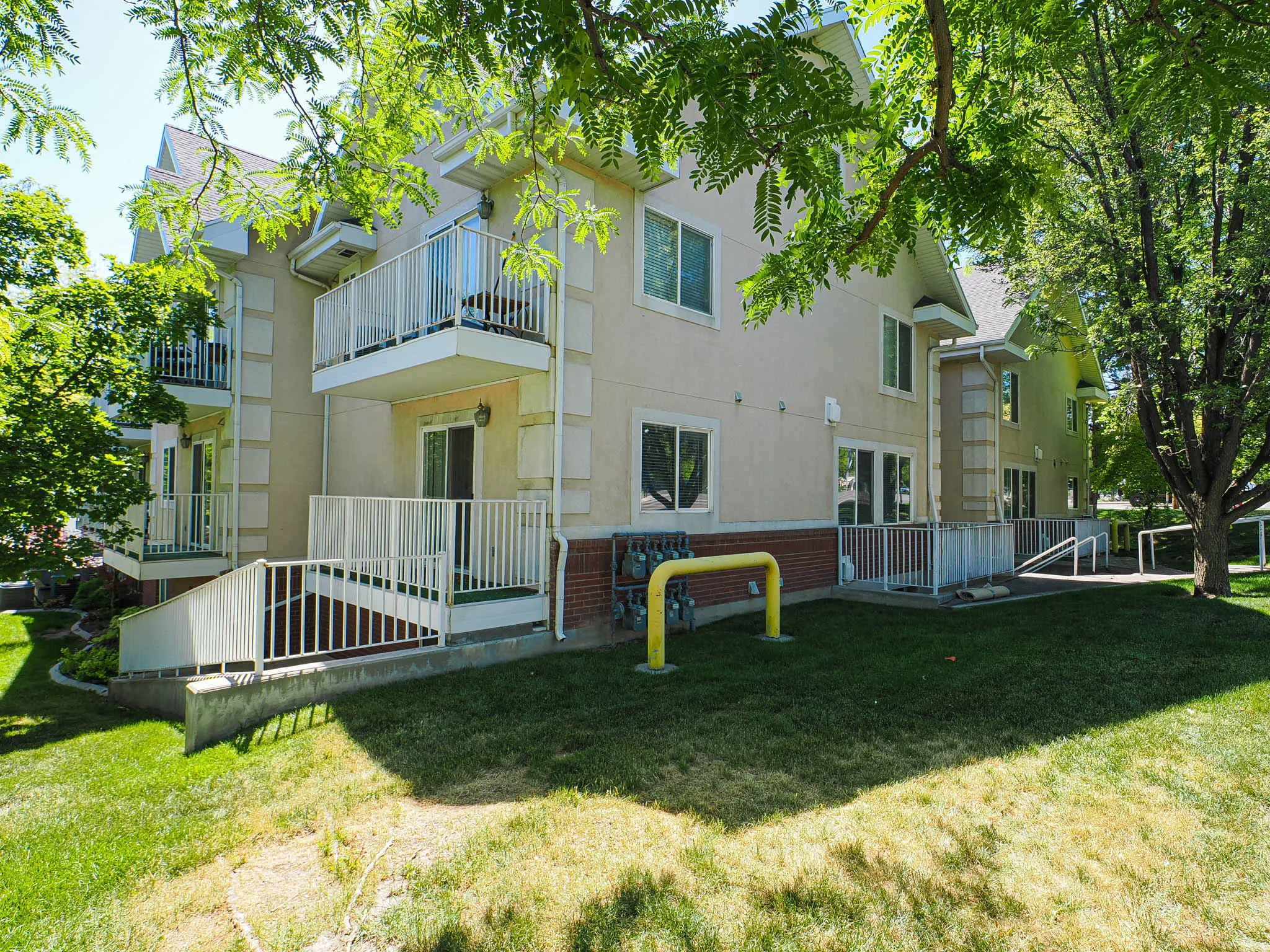 Multi-story stucco building featuring multiple balconies with white railings