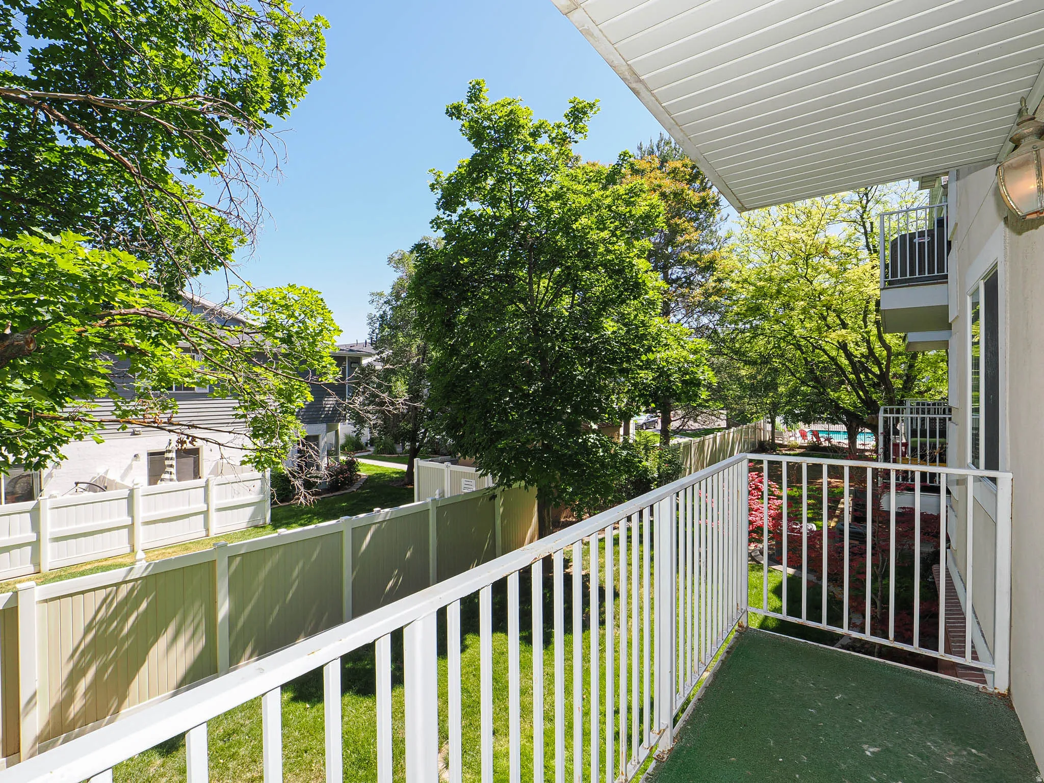 Private balcony featuring white railings and a green outdoor carpet