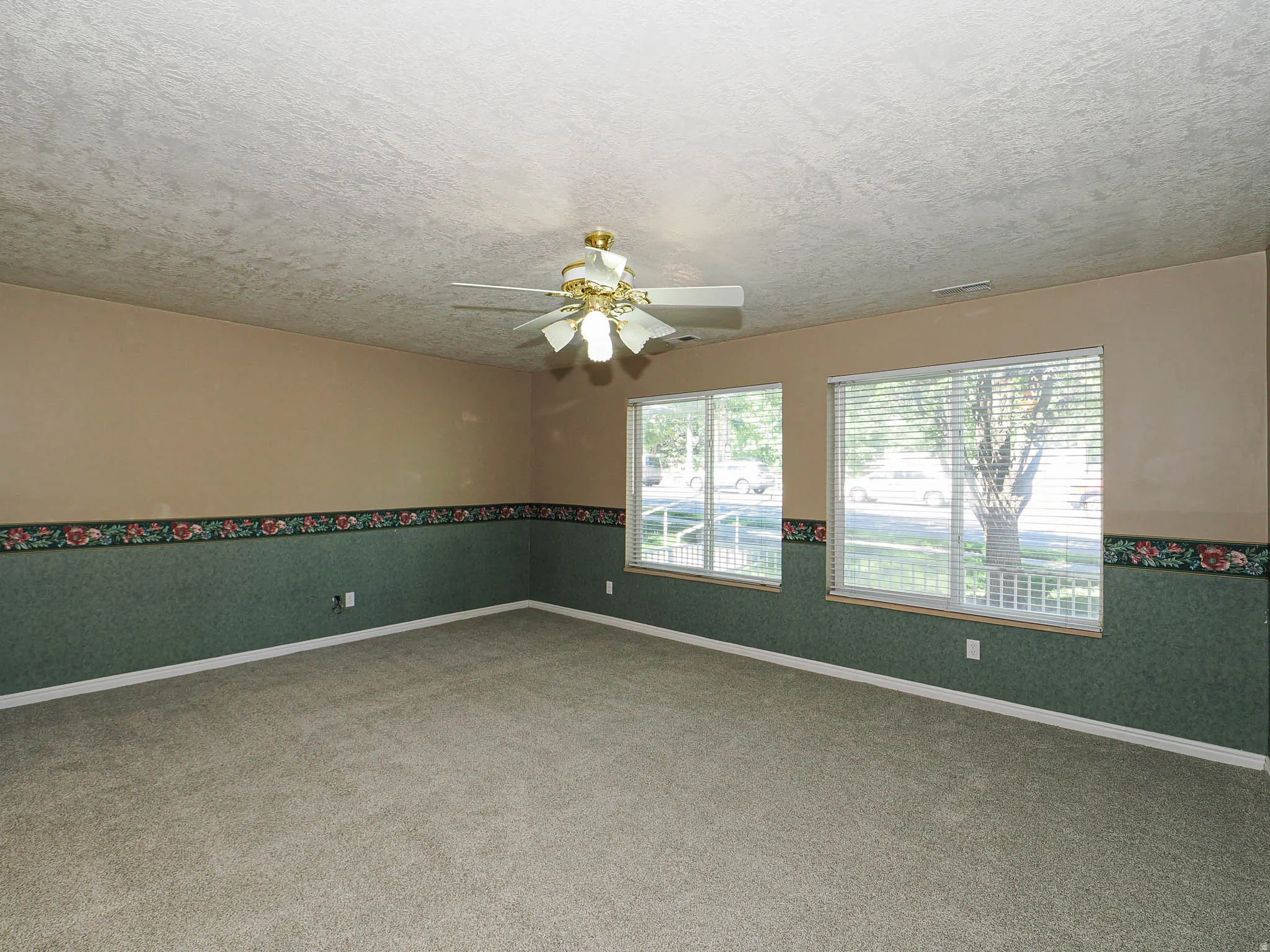 Spacious room with carpet flooring and dual windows providing natural light