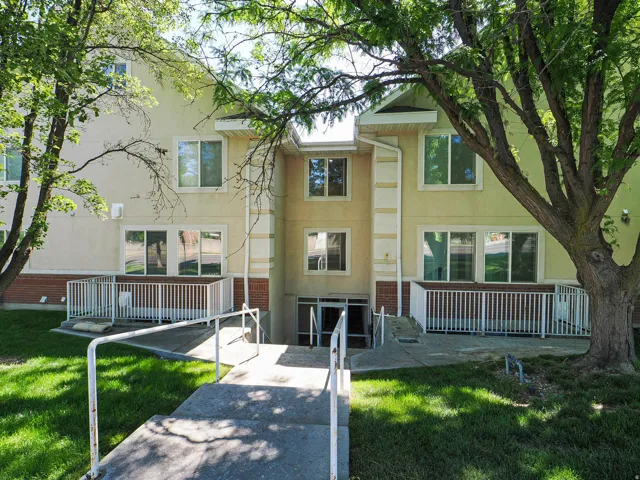 Multi-level building exterior featuring stucco siding and brick veneer