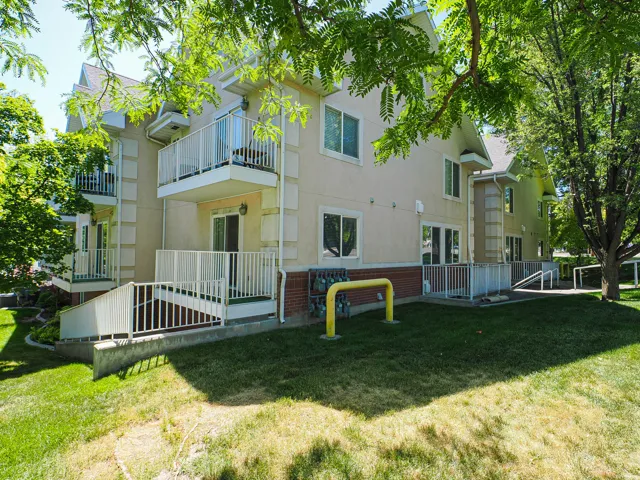 Multi-story stucco building featuring multiple balconies with white railings