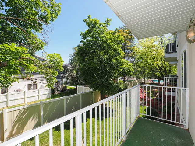 Private balcony featuring white railings and a green outdoor carpet